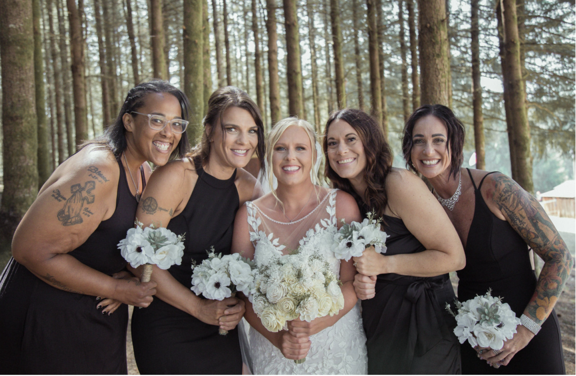 Bridal party posing for wedding photos in a beautiful forest area.